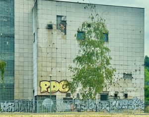 Detalle de la fachada brutalista del edificio Atos Osiguranje en Sarajevo, marcada por impactos de proyectiles de la guerra de Bosnia.