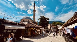 Vista de la calle Baščaršija en Sarajevo con el minarete y el domo de la mezquita Baščaršijska al fondo.