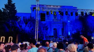 Escenario del Festival Kultura na Ulice! (KNU! 2025) antes de comenzar una presentación nocturna en la explanada del Teatro Nacional de Sarajevo.