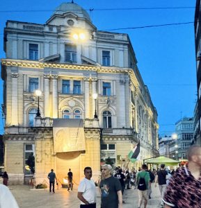 Manifestación por Palestina frente al monumento Vječna vatra, con velas y banderas ondeando al anochecer en Sarajevo.